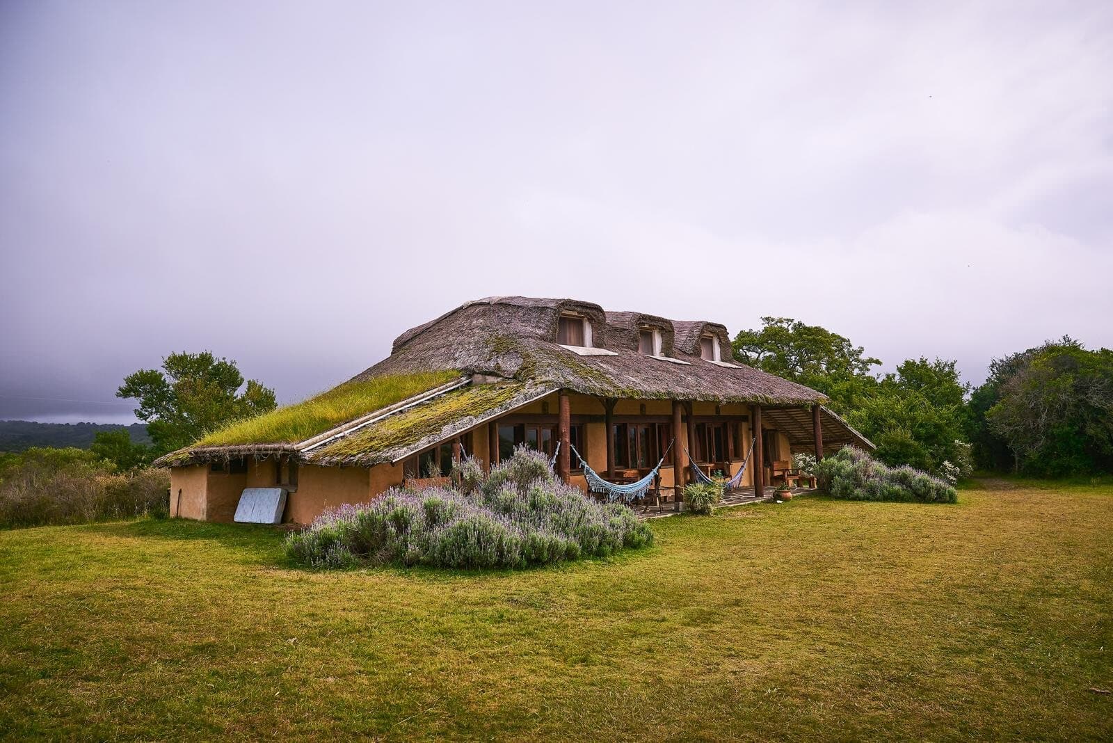 La posada de techo de paja y muros de barro, con el jardín de lavanda adelante