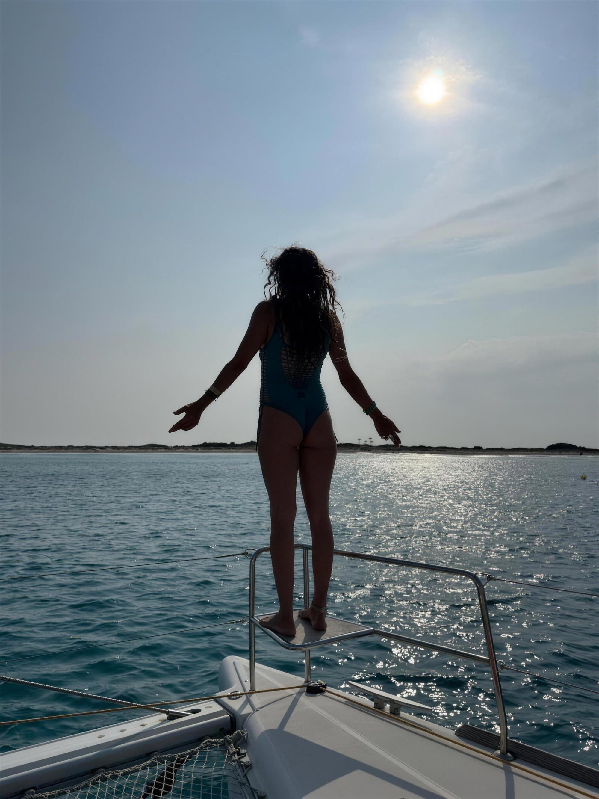 Velero navegando solo en mar abierto contra un cielo dorado, al caer el sol