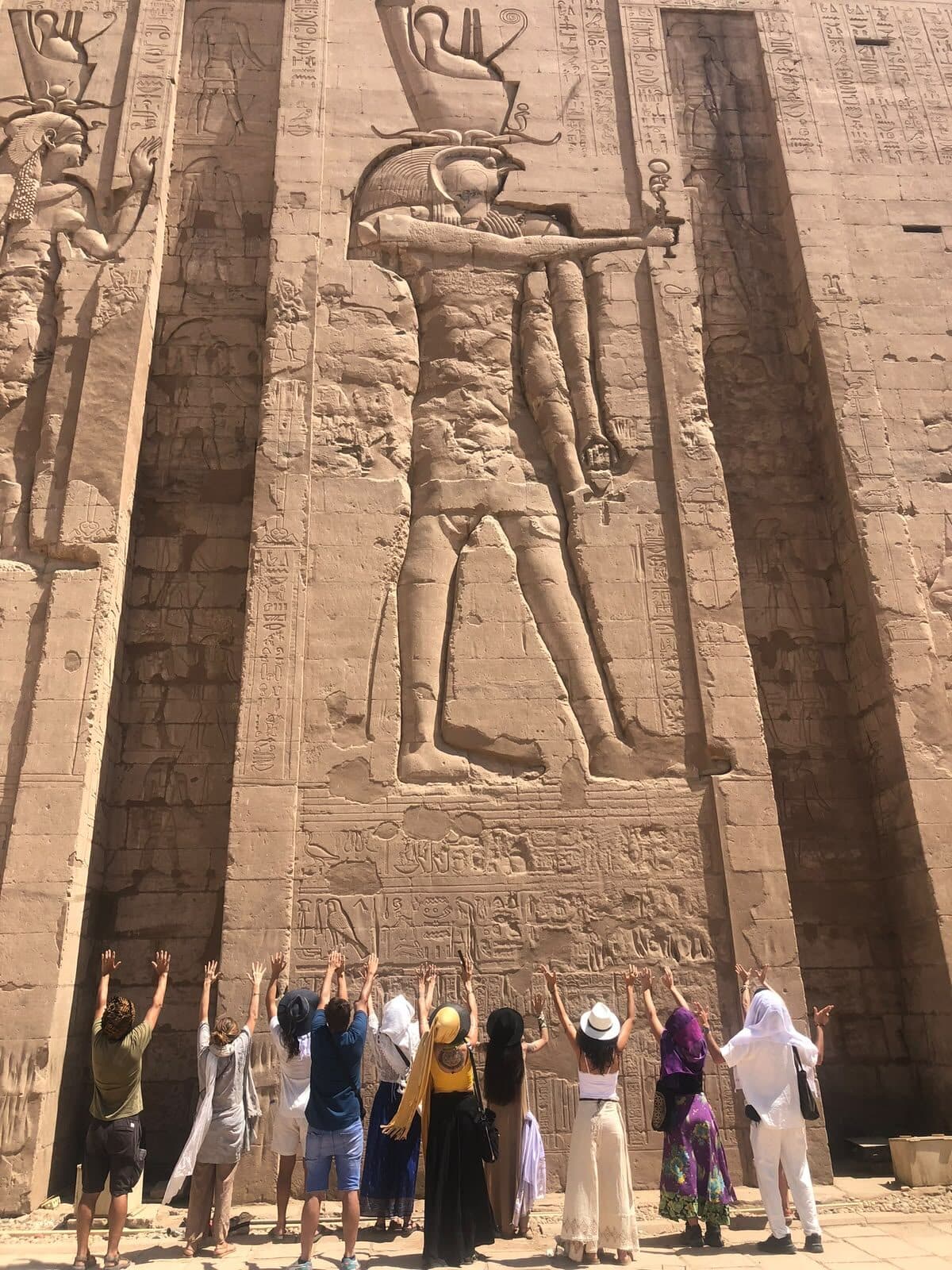 El grupo con los brazos en alto frente al relieve monumental de Abu Simbel