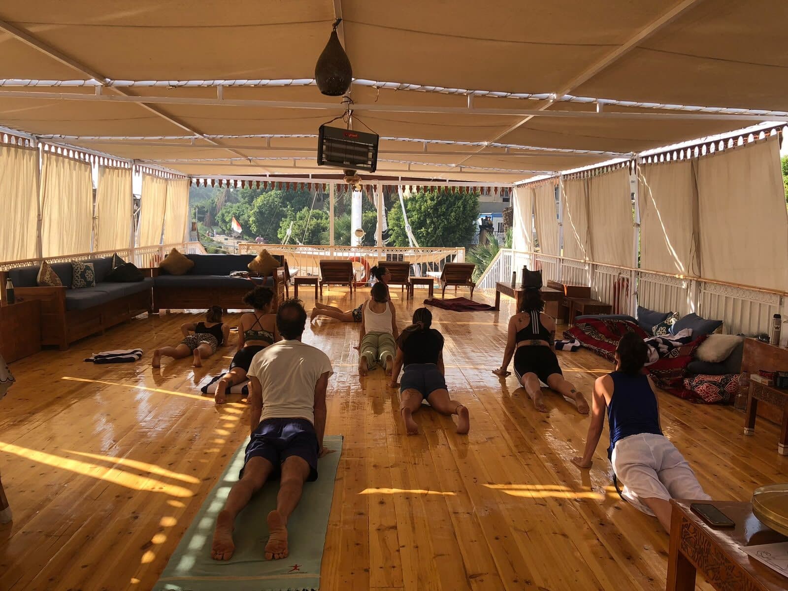 Práctica de yoga sobre la cubierta techada del barco, a primera hora